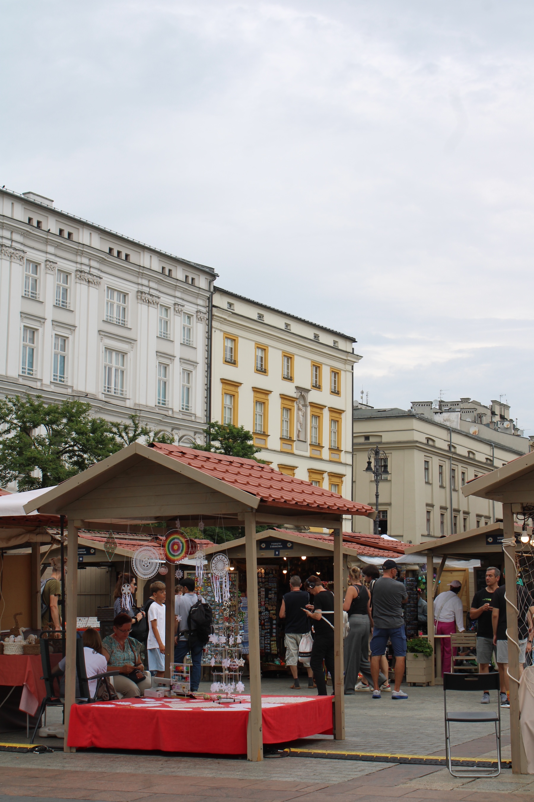 Candy-colored roofs line the background of a pop-up market in the town square