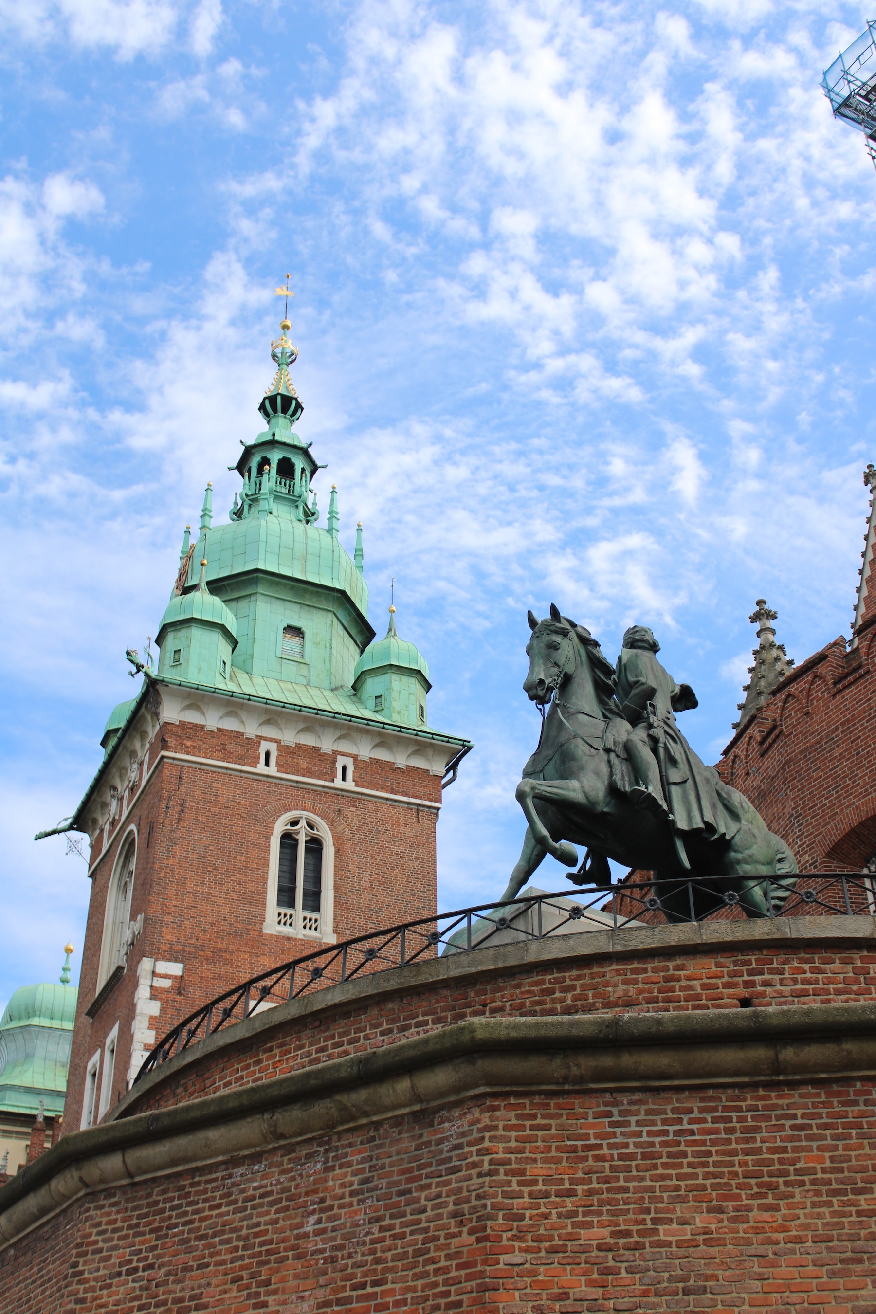 A statue of a man on horseback, and a castle tower in the background