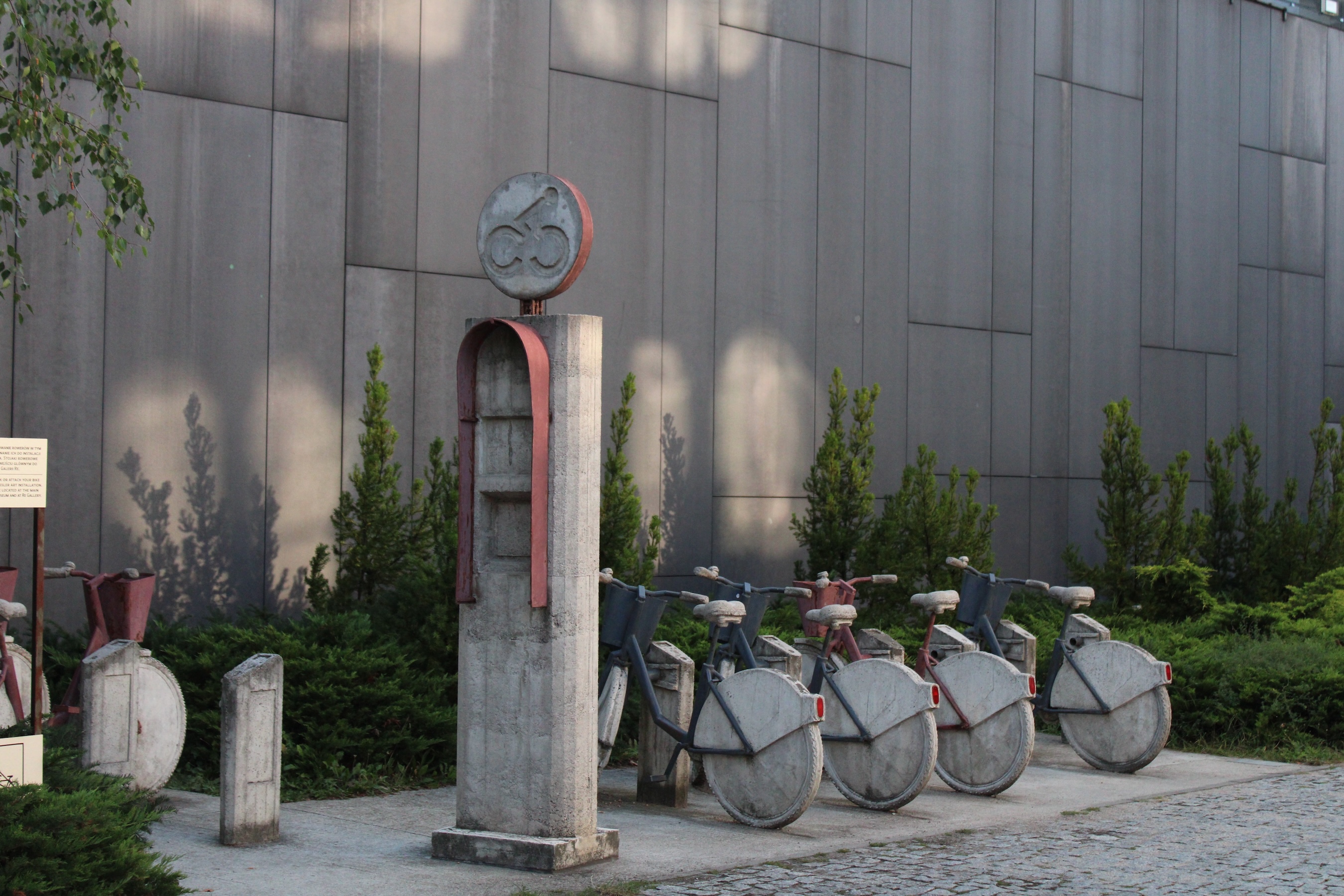 An art installation of a citi-bike rack. The renting booth and bike wheels are make of concrete. The bike frames are made of spray painted steel.