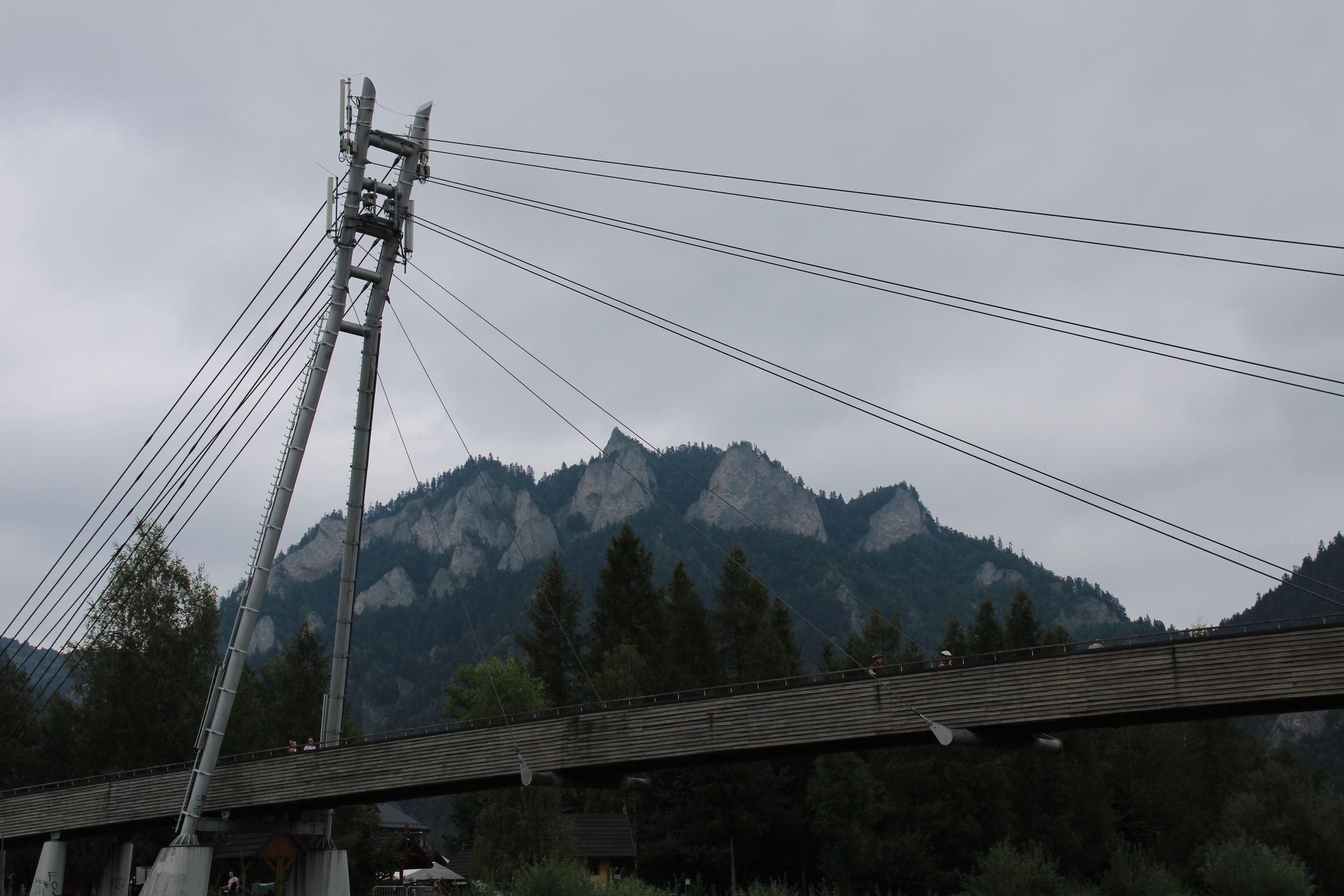 A suspension bridge in the foreground, and the Three Crowns mountain in the background.