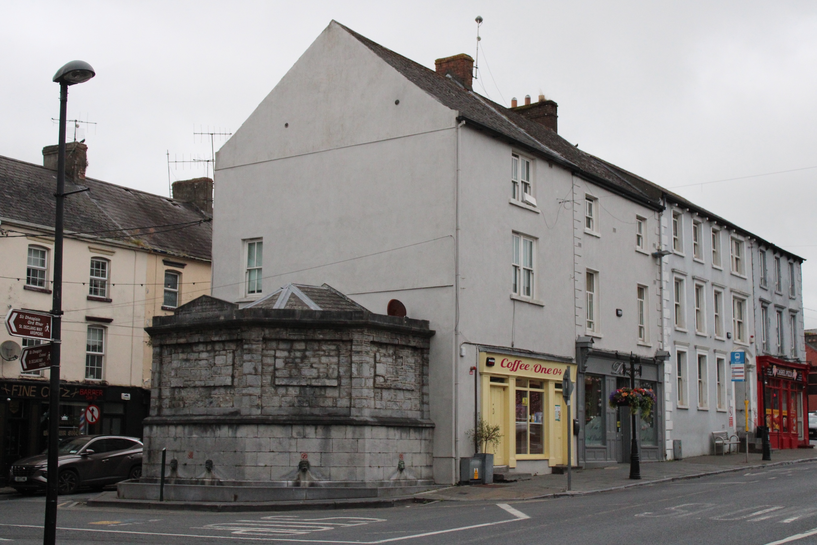 A coffee store at the corner of an intersection in Cashel. The sky is grey and cloudy.