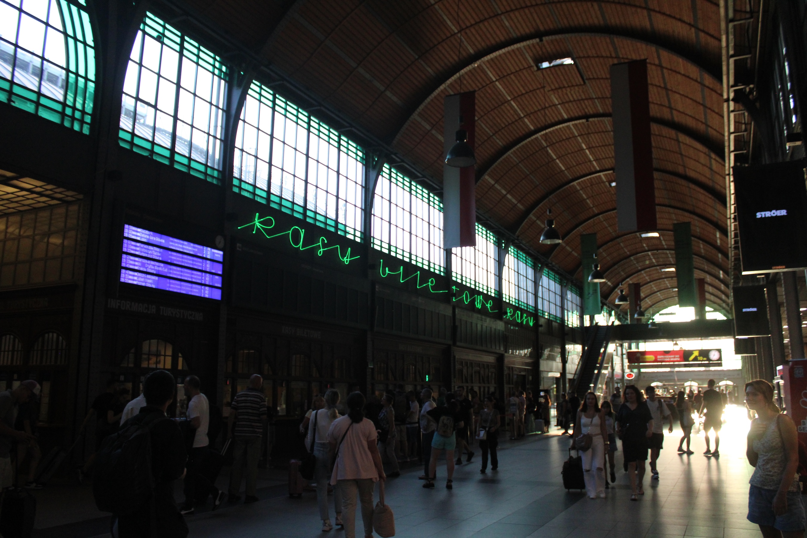 The dark interior of the train station is lit by high-up windows lining the corridor