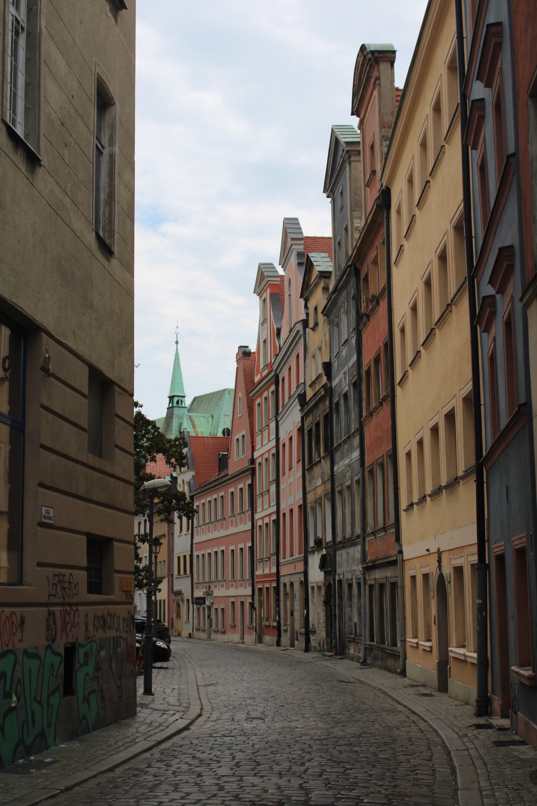 An alleyway of pastel-painted buildings curves off to the left