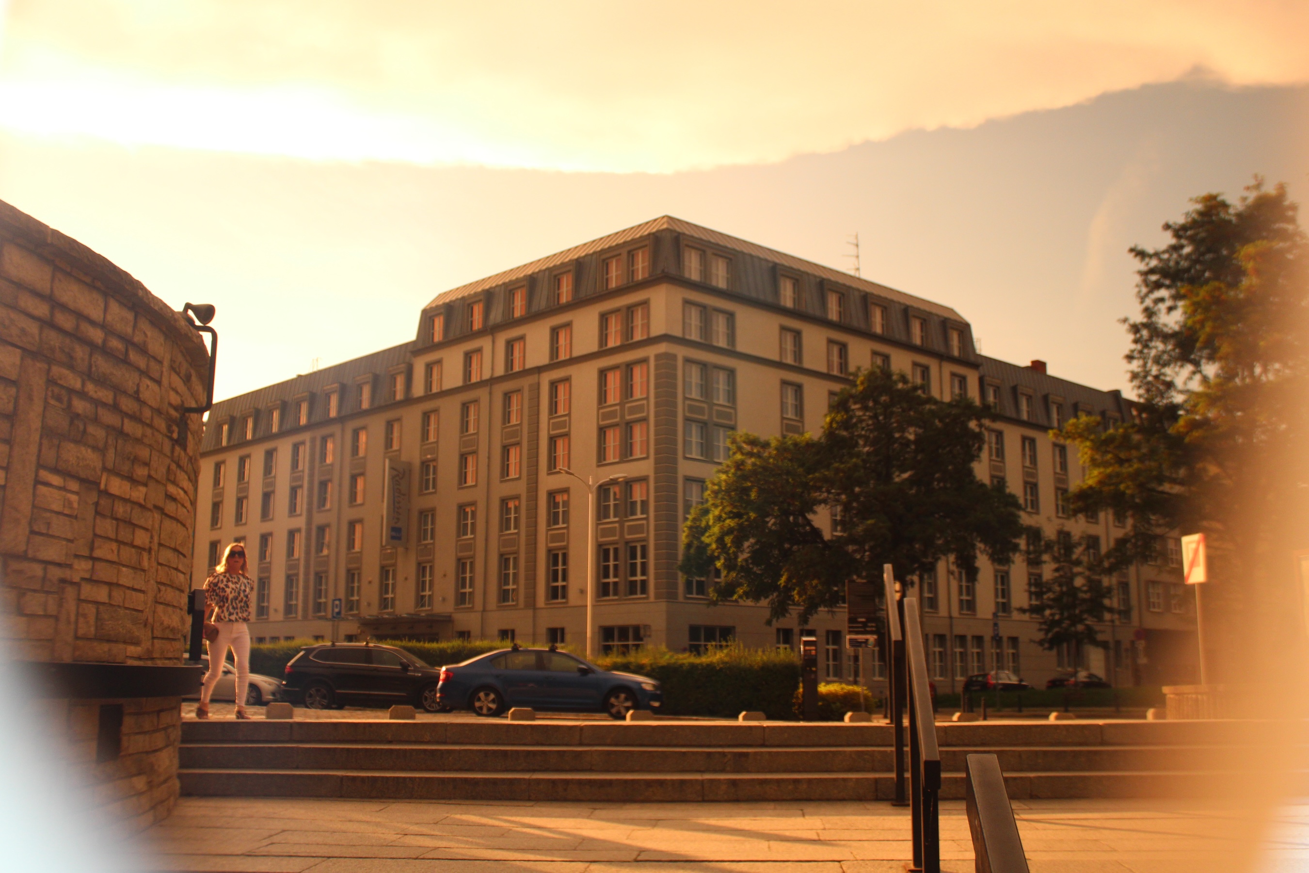 A shot through sepia-tinted sunglasses of a short stairway and the corner of a building. The edges of the glasses can be seen near the edge of the image